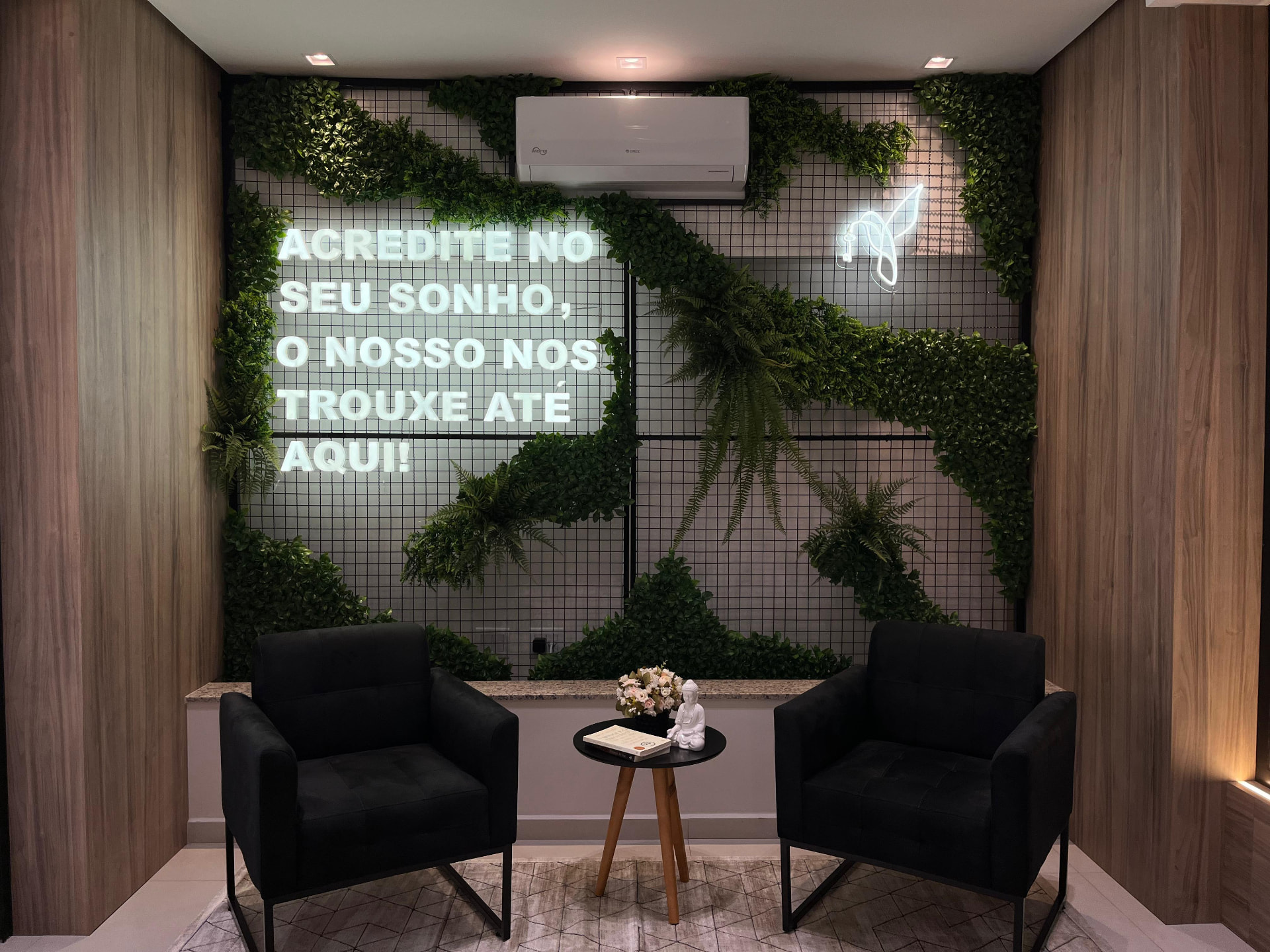 Painel em neon com frase motivacional em parede verde